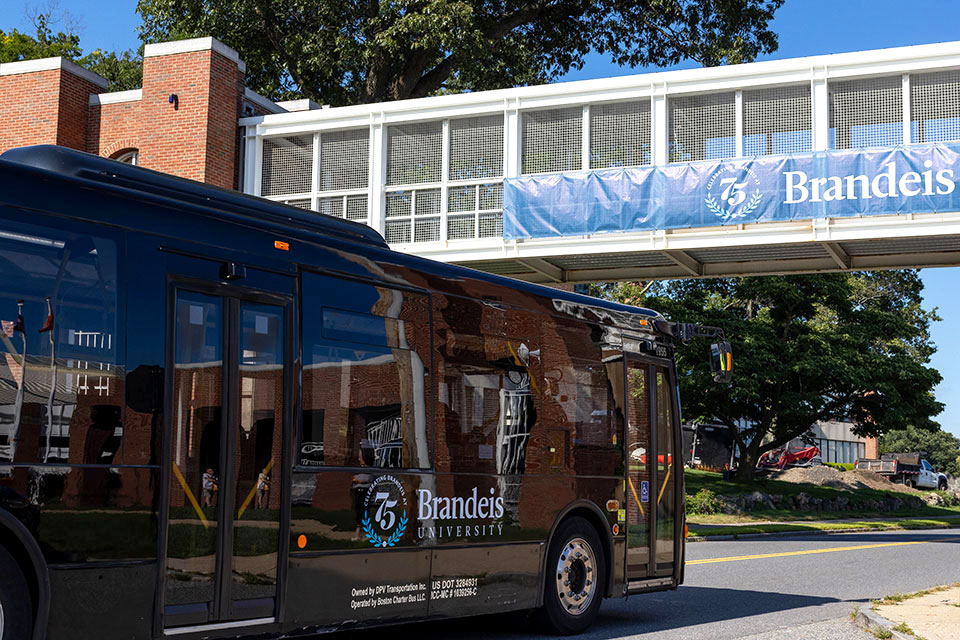 The Brandeis shuttle passing under a bridge on campus.