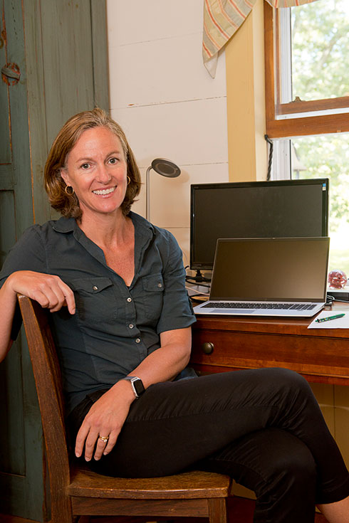 Jenneke smiles at the camera while sitting at her desk