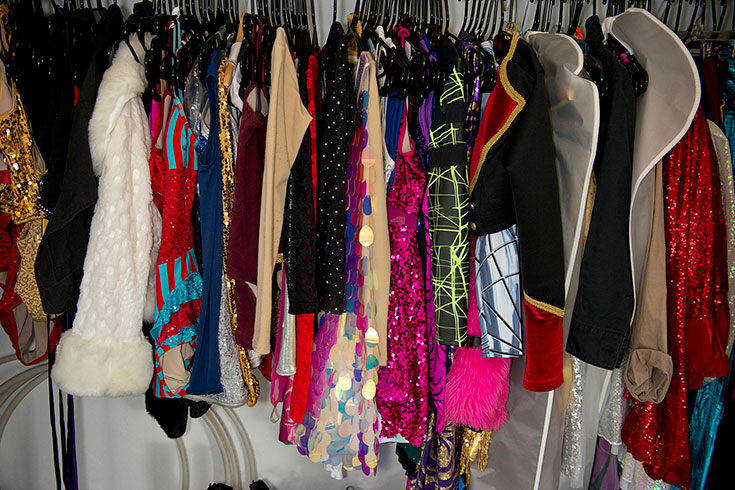 Sparkly, colorful costumes hang on a rack