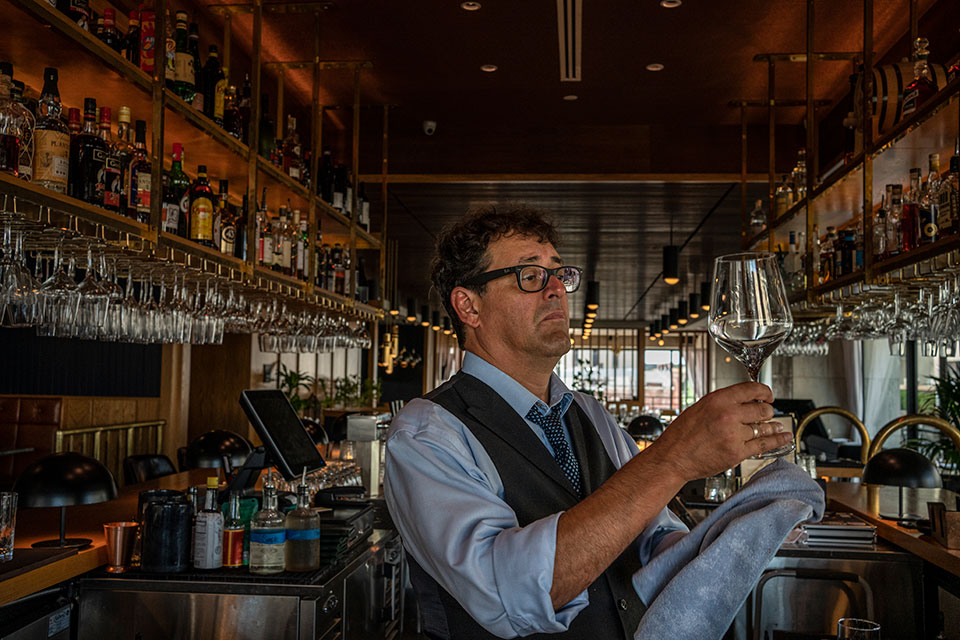 Ricardo behind the bar, cleaning a glass