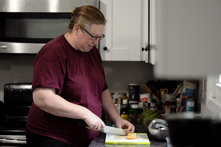 Sharon cuts an orange in a kitchen