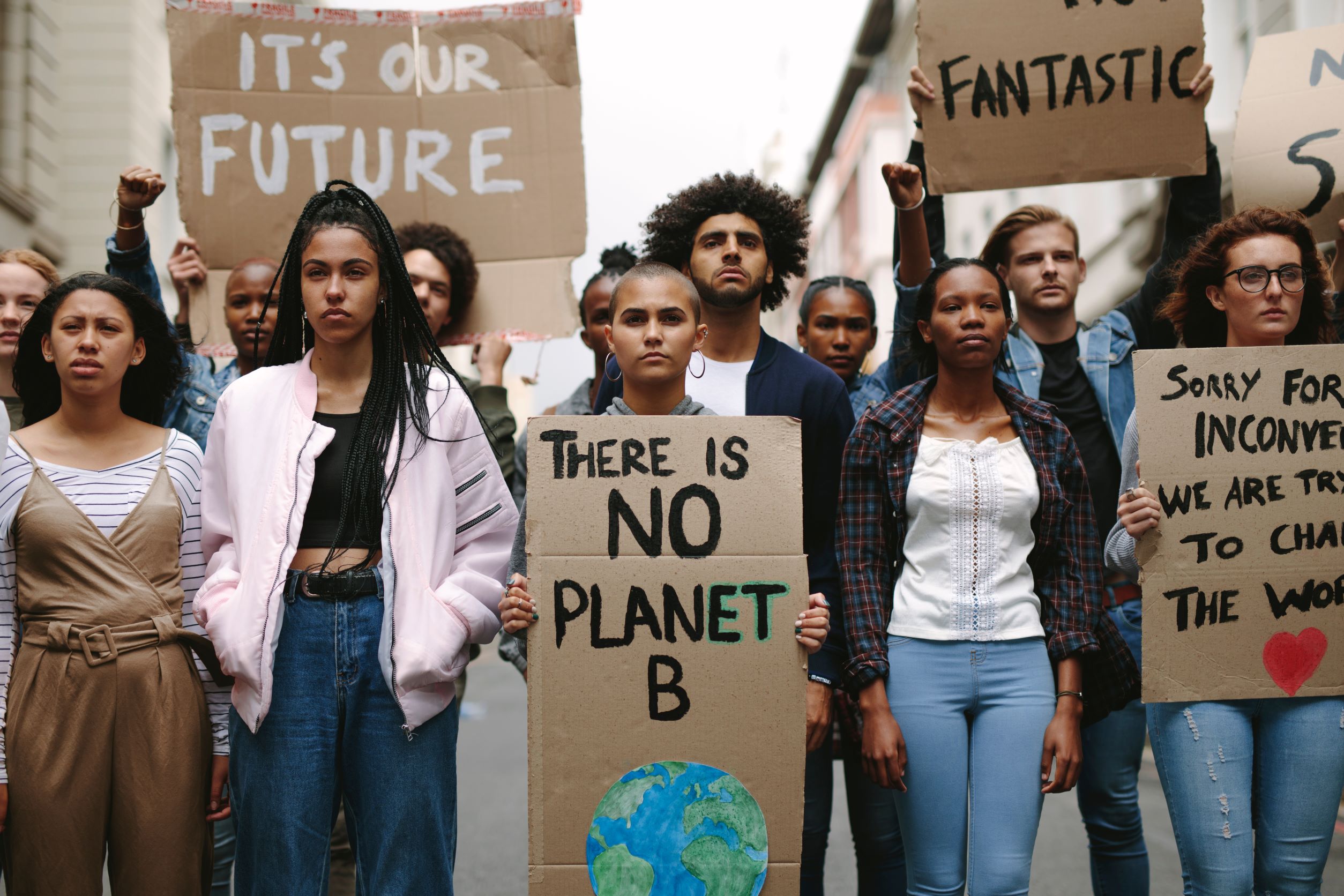 Group of activists with banners protesting to save earth. Men and women rebellions doing a silent protest over global warming and pollution.