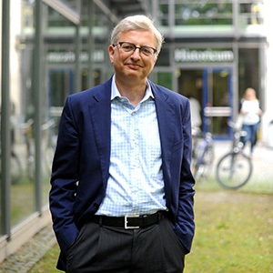 Portrait of Michael Brenner with a soft smile and hands in pockets