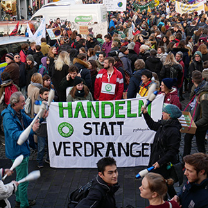 Image of climate activists at a rally holding a large sign