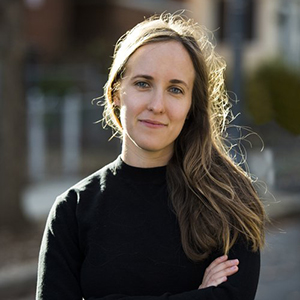 Head shot of Linda Kinstler in a black shirt smiling