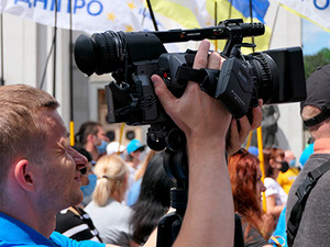 Man with a news camera in a crowd
