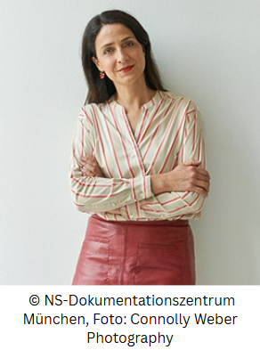 Color photograph of Miriam standing with her arms crossed looking at the camera
