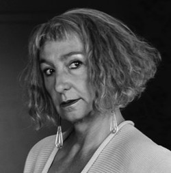 Headshot of Adrienne in black and white looking at the camera seriously