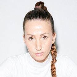 Headshot of Rita Schuhmacher looking seriously at camera