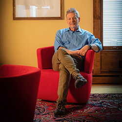 Image of Jack El-Hai sitting with his legs crossed on a sofa