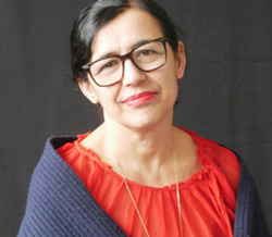 Head shot of the Director with a soft smile looking at the camera