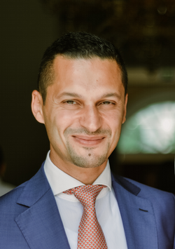 Head shot of Farid Hafez in a suit with a soft smile