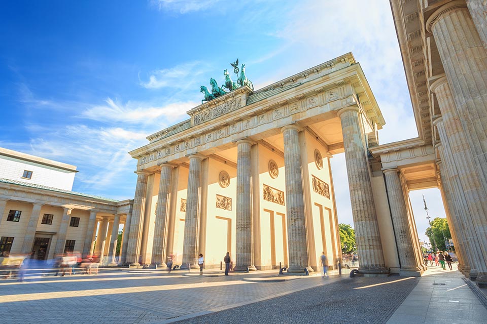 People walking around the Brandenburg Gate in Berlin at Dusk