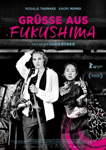 Film poster for movie. Text reads: Grusse Aus Fukushima, ein film von Doris Dorrie.  Rosalie Thomass, Kaori Momoi.  Black and white photo of a tall young woman with a walking stick and backpack standing next to an Asian woman carrying a bundle.