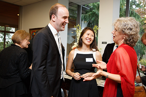 Panelist Kai Keller '07 and Sophie Keller talk with CGES Director Sabine von Mering at the welcome reception, all with big smiles.