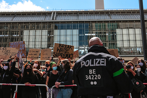 Picture of a German police officer facing a crowd
