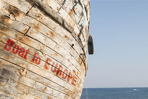 Boat on the ocean with the text 'Boat to Europe' in red