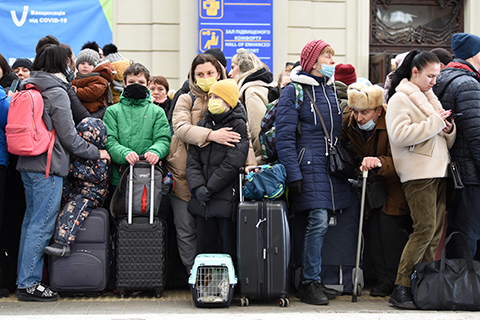 Group of people standing on a train platform waiting