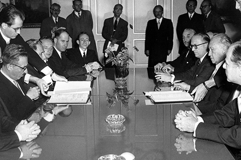 Black and white photo of politicians around a large table