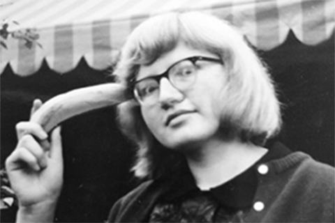 Black and white photo of Luise Pusch holding a banana to her head