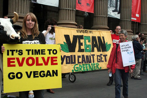 People holding pro-vegan signs at a rally