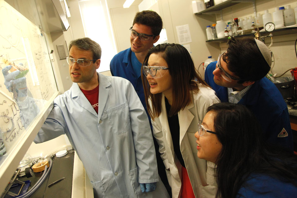 Prof. Isaac Krauss leads and experiment in the lab with students 