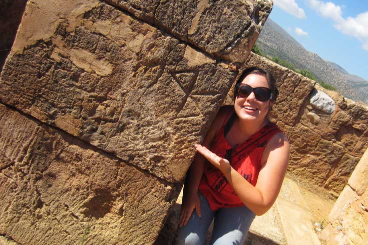 Belisi Gillespie standing next to a column, pointing