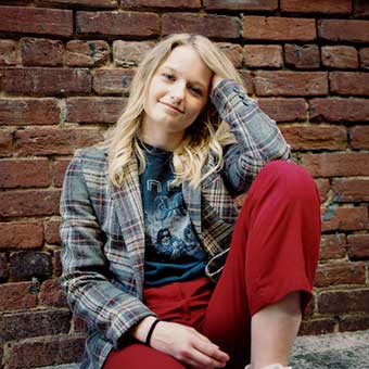 Riley sitting by a wall