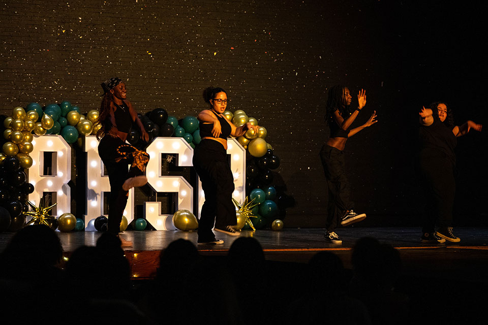 Students from BBSO dance together on stage.