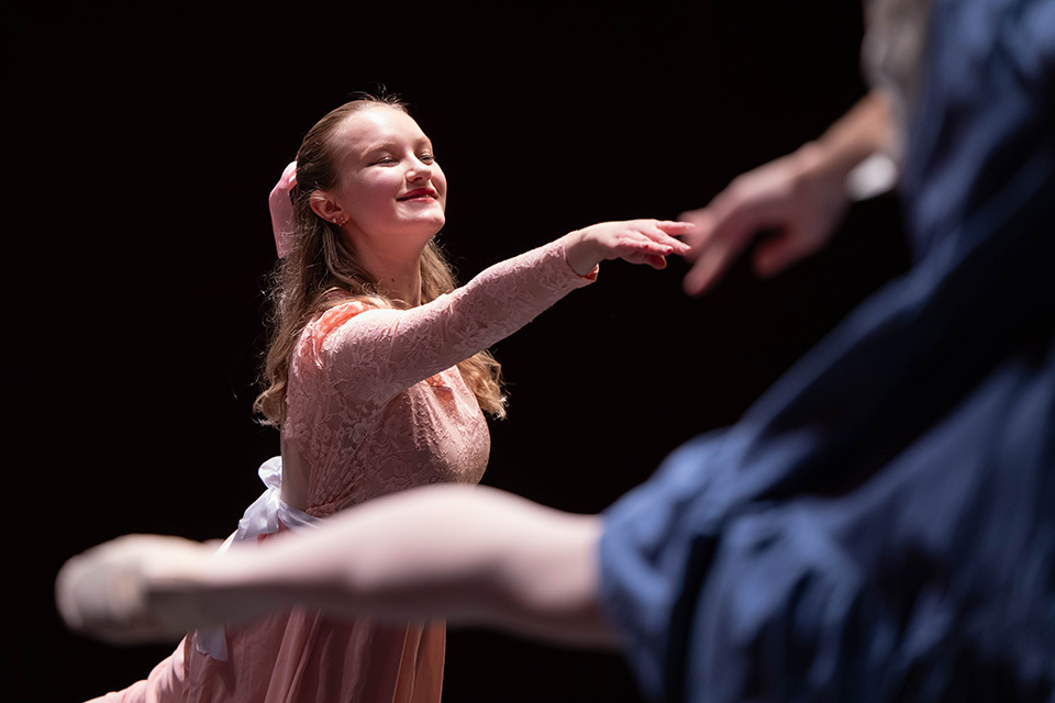 A ballerina dances on stage.