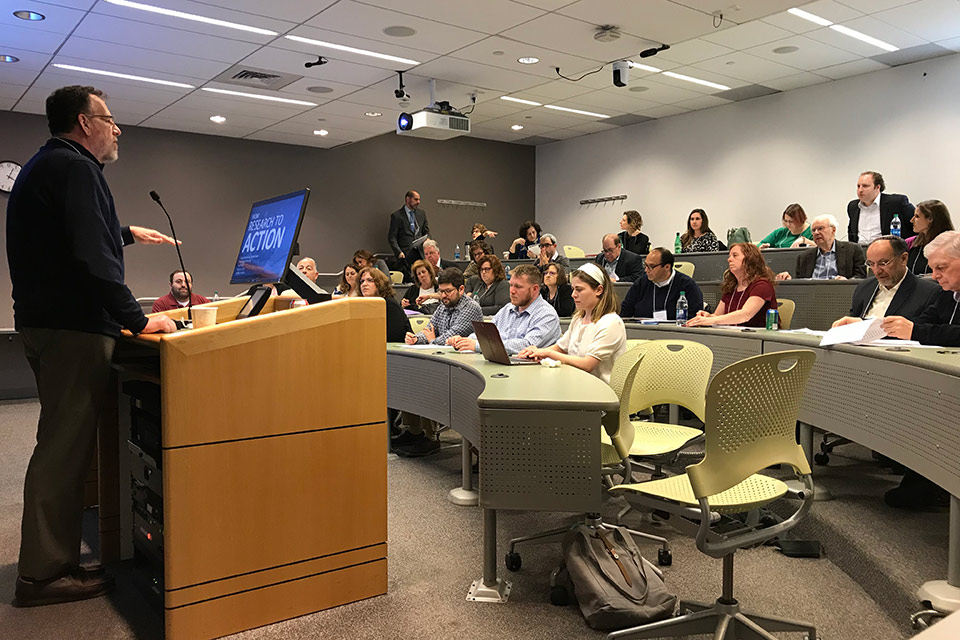 Len Saxe speaks to a room full of conference participants