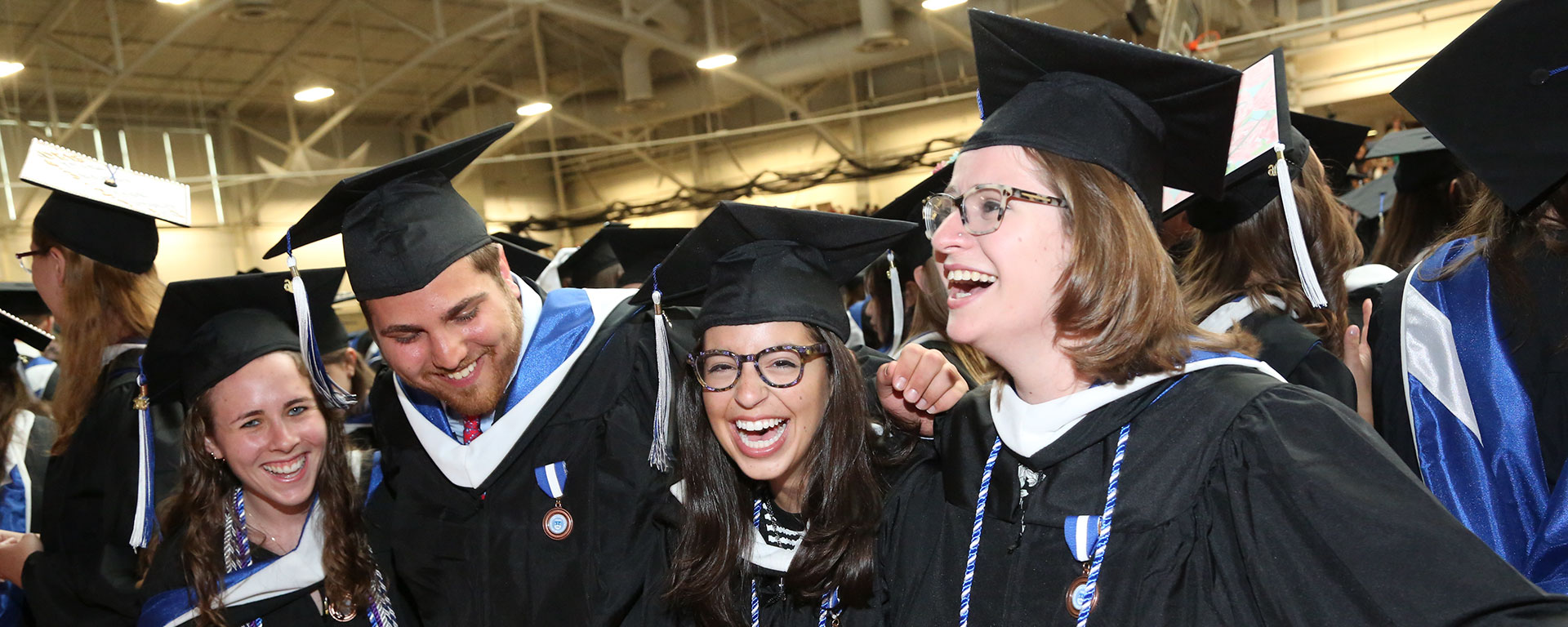 Laughing students in caps and gowns 