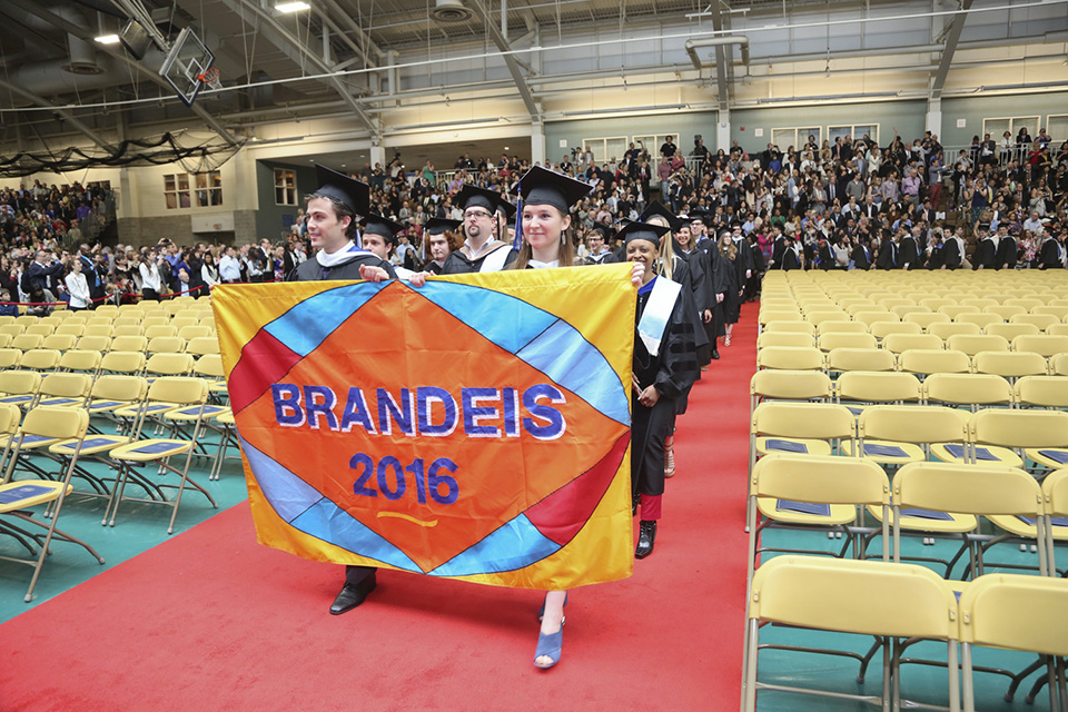 The Class of 2016 carries their flag (which says "Brandeis 2016") as they march down the aisle