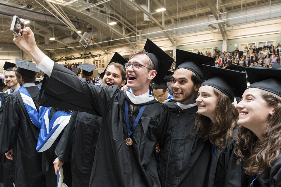 Five graduates pose for a selfie