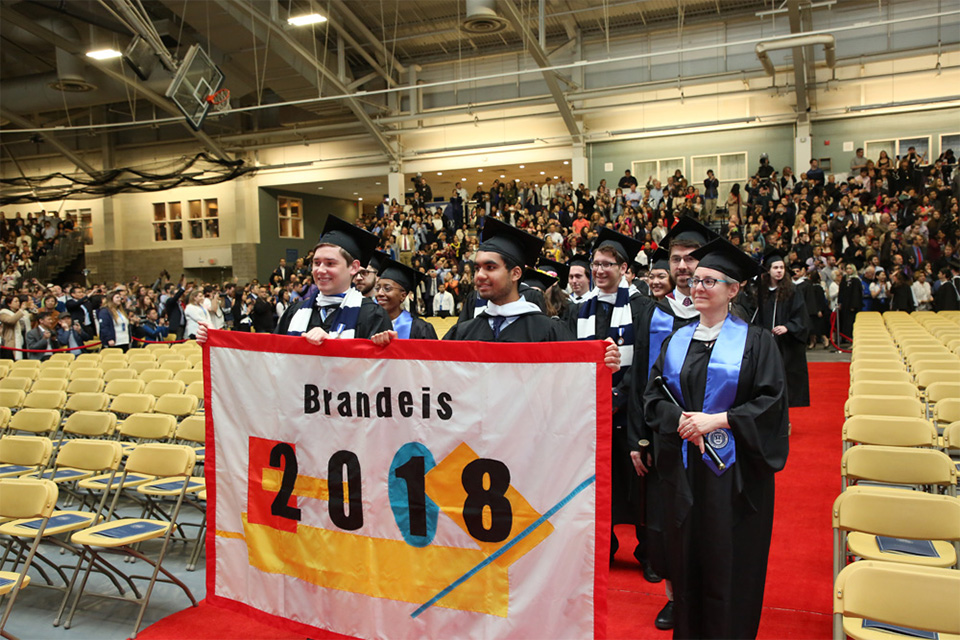 Graduates hold a banner that says 2018