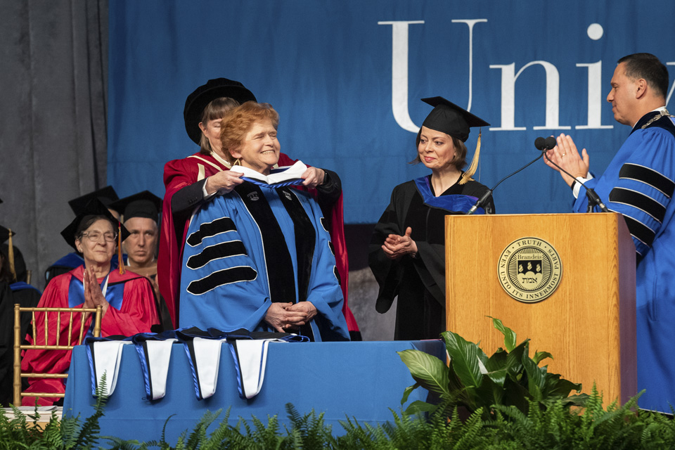 Provost Lisa Lynch places a hood over Deborah Lipstadt's head, while Laura Jockusch and President Liebowitz look on