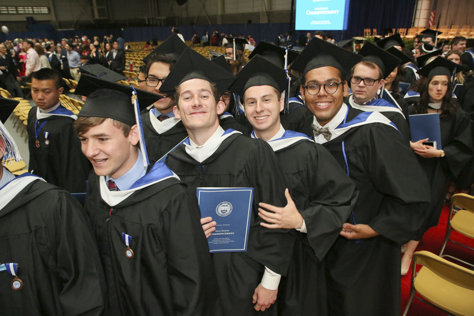 Students in caps and gowns filing in to their seats