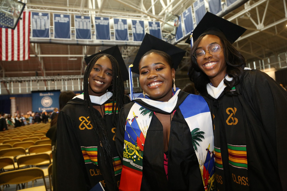 Three graduate students smile for the camera