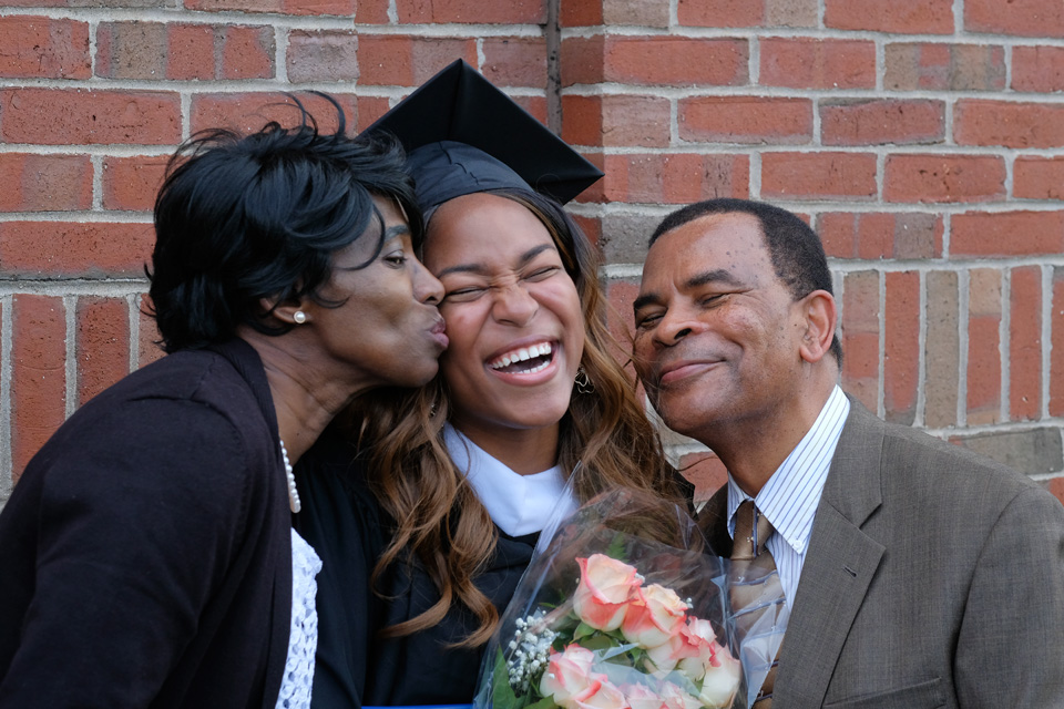 A graduate stands between her parents