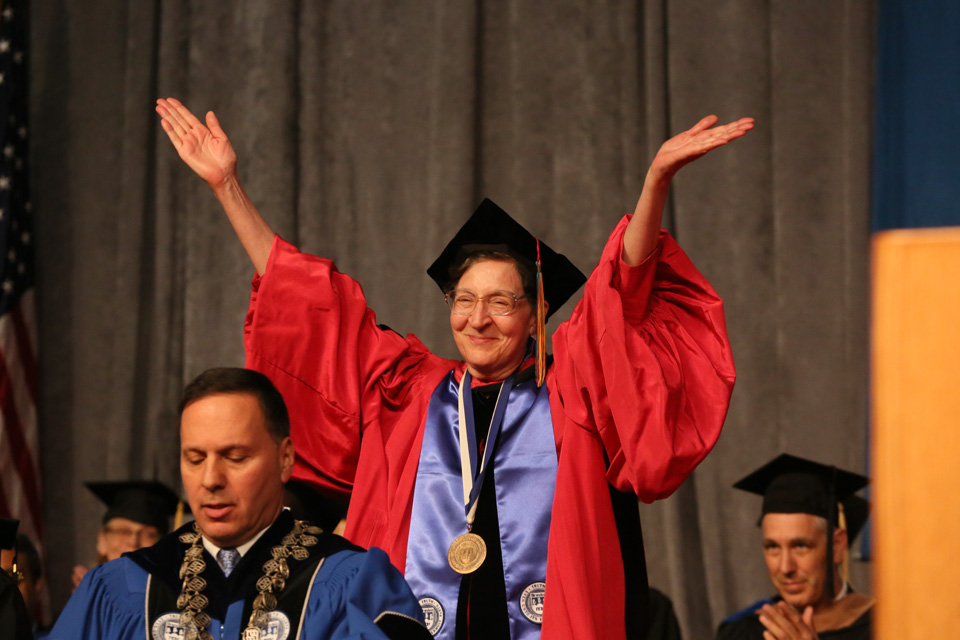 Bernadette Brooten stands with her hands in the air