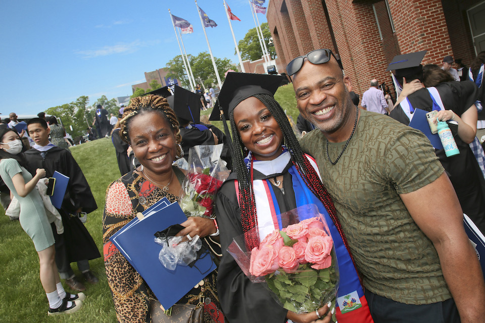 A family smiles with their graduate