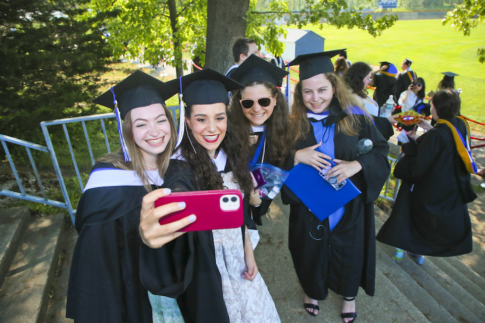 Smiling graduates pose for a selfie