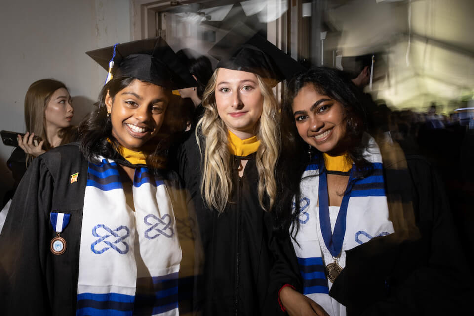 Vishni Samaraweera '23, Ariel Sapozhnikov '23, and Krupa Sourirajan '23 pose for a photo as they wait for the ceremony to begin in the tunnel beneath Gosman Sports and Convocation Center.