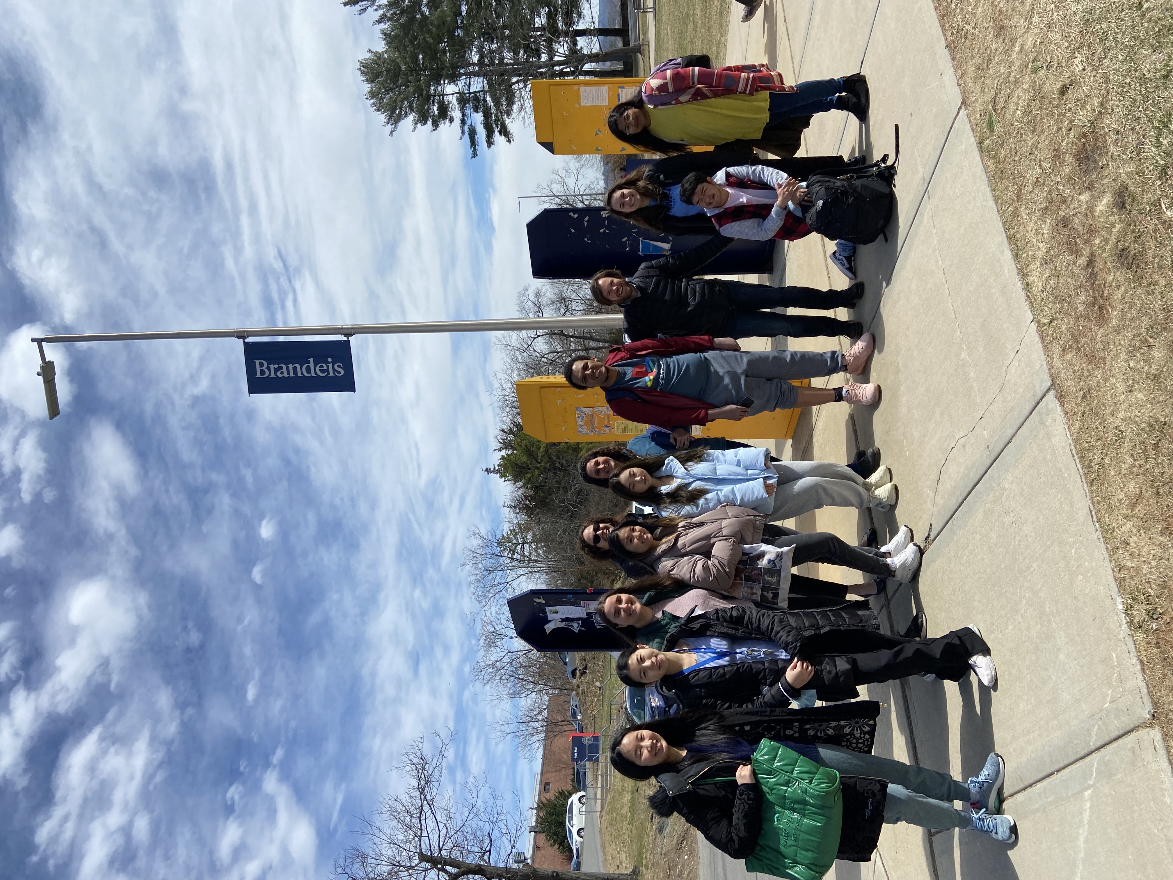 Group of students standing outside beneath a sign post