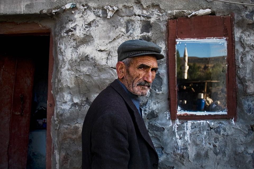 an old man standing in front of the wall