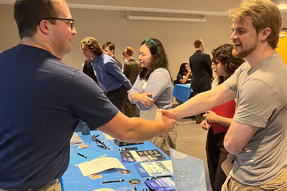 Student shaking an industry rep's hand