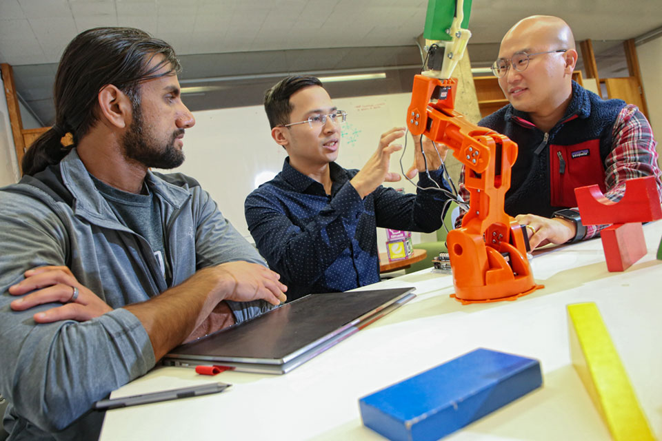 Three students work on a robot