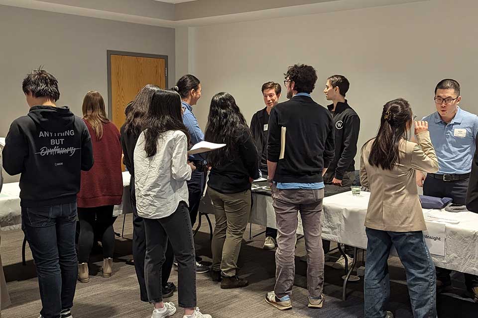 Students at industry event tables