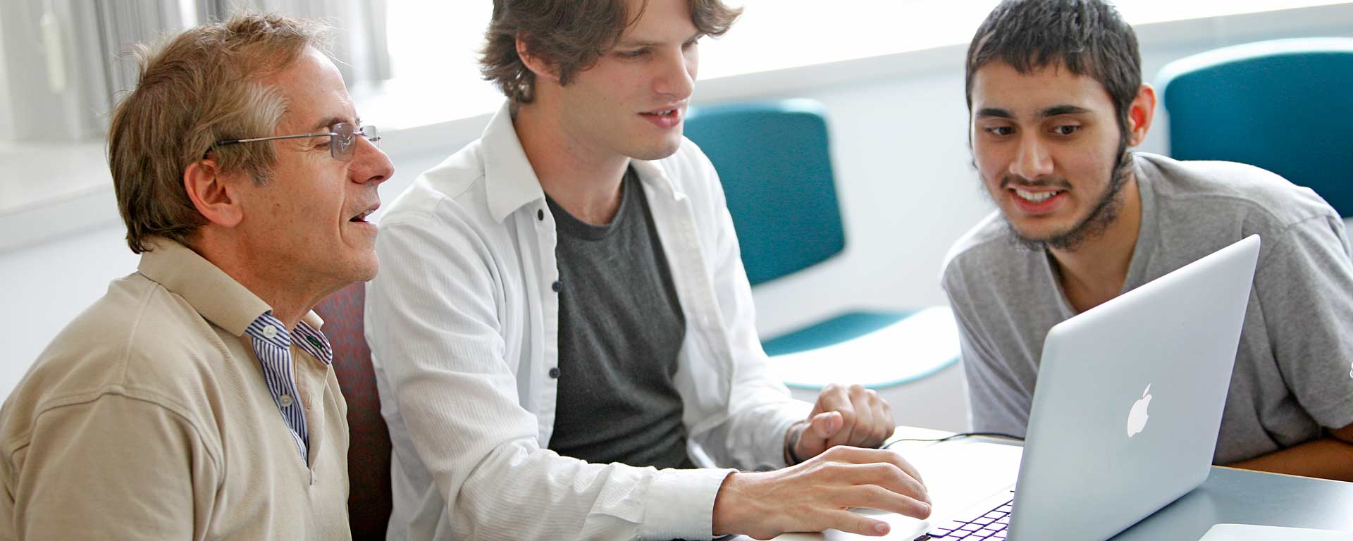 Professor working with two students on application development