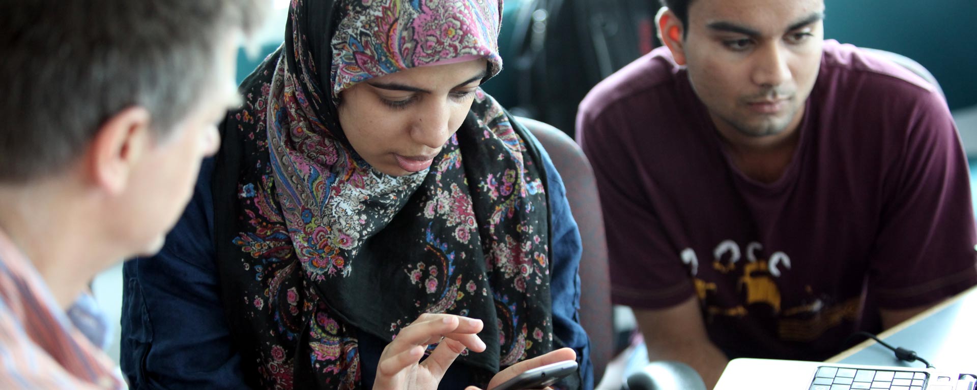 Professor working with two students on application development